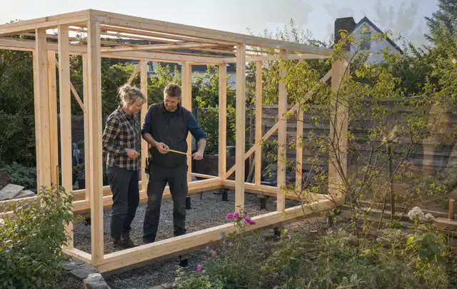 Person plant den Bau eines Gartenhauses auf einer vorbereiteten Fläche; Thema Gartenhaus aus Metall, Schwerpunkt Gestaltung; Kontrolle.