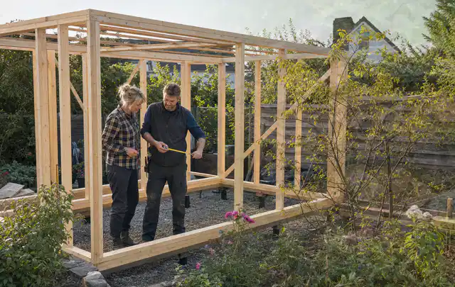 Person plant den Bau eines Gartenhauses auf einer vorbereiteten Fläche; Thema Gartenhaus aus Metall, Schwerpunkt Planung; Ausgangslage.