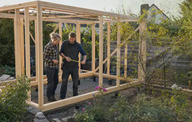 Person plant den Bau eines Gartenhauses auf einer vorbereiteten Fläche; Thema Gartenhaus Dach, Schwerpunkt Fehlerhilfe; Kontrolle.