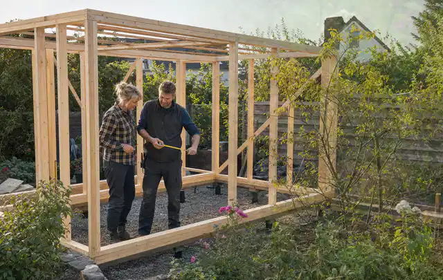 Person plant den Bau eines Gartenhauses auf einer vorbereiteten Fläche; Thema Gartenhaus Dach, Schwerpunkt Gartenhäuser; Kontrolle.