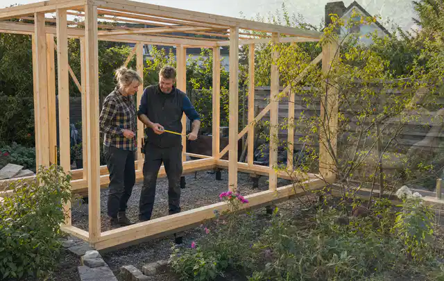 Person plant den Bau eines Gartenhauses auf einer vorbereiteten Fläche; Thema Gartenhaus Dach, Schwerpunkt Kosten; Kontrolle.
