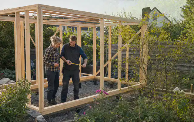 Person plant den Bau eines Gartenhauses auf einer vorbereiteten Fläche; Thema Gartenhaus Dach, Schwerpunkt Materialwahl; Ergebnis.