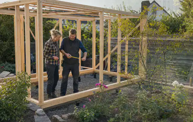 Person plant den Bau eines Gartenhauses auf einer vorbereiteten Fläche; Thema Gartenhaus Dach, Schwerpunkt Nachhaltigkeit; Ausgangslage.