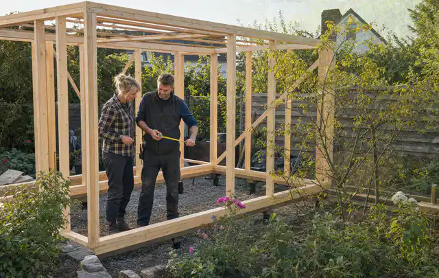 Person plant den Bau eines Gartenhauses auf einer vorbereiteten Fläche; Thema Gartenhaus Dach, Schwerpunkt Planung; Praxisalltag.