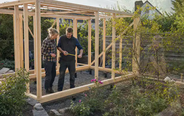Person plant den Bau eines Gartenhauses auf einer vorbereiteten Fläche; Thema Gartenhaus Fenster, Schwerpunkt Fehlerhilfe; Umsetzung.
