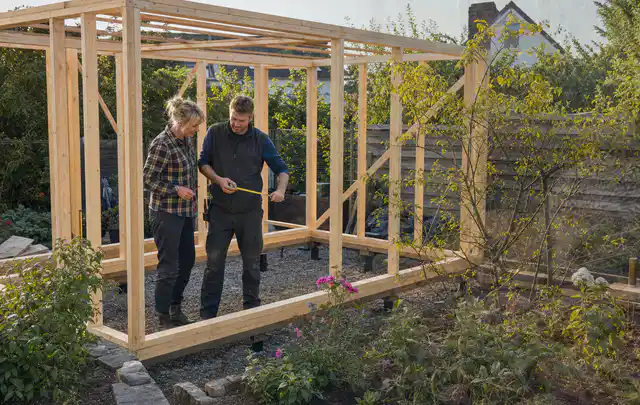 Person plant den Bau eines Gartenhauses auf einer vorbereiteten Fläche; Thema Gartenhaus Fenster, Schwerpunkt Pflege; Umsetzung.