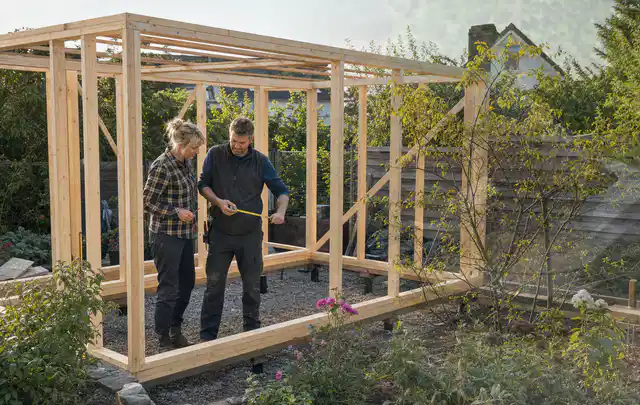 Person plant den Bau eines Gartenhauses auf einer vorbereiteten Fläche; Thema Gartenhaus Fenster, Schwerpunkt Planung; Umsetzung.