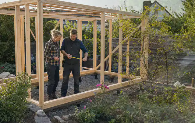 Person plant den Bau eines Gartenhauses auf einer vorbereiteten Fläche; Thema Gartenhaus Fenster, Schwerpunkt Winterschutz; Ausgangslage.