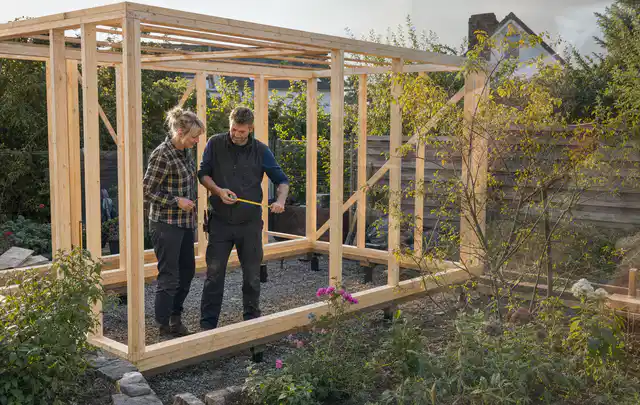 Person plant den Bau eines Gartenhauses auf einer vorbereiteten Fläche; Thema Gartenhaus Fundament, Schwerpunkt DIY; Ausgangslage.
