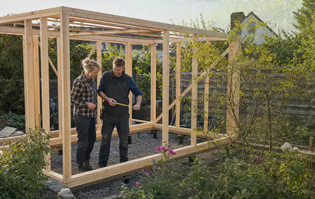 Person plant den Bau eines Gartenhauses auf einer vorbereiteten Fläche; Thema Gartenhaus Fundament, Schwerpunkt Gartenhäuser; Kontrolle.