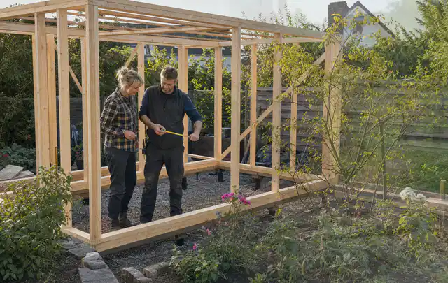 Person plant den Bau eines Gartenhauses auf einer vorbereiteten Fläche; Thema Gartenhaus Fundament, Schwerpunkt Gestaltung; Ergebnis.