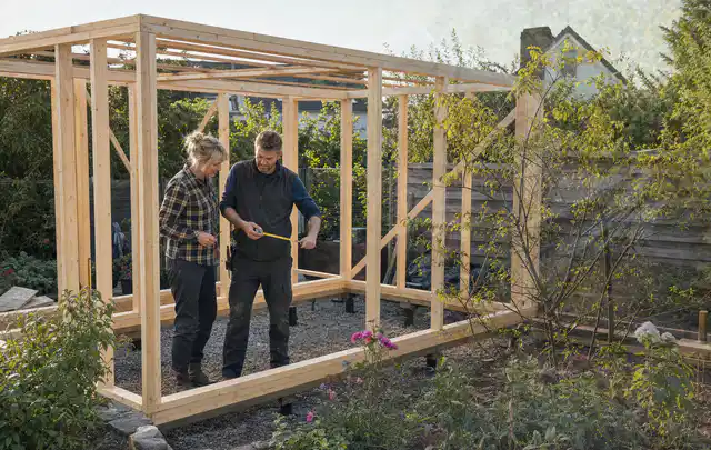 Person plant den Bau eines Gartenhauses auf einer vorbereiteten Fläche; Thema Gartenhaus Fundament, Schwerpunkt Materialwahl; Ergebnis.
