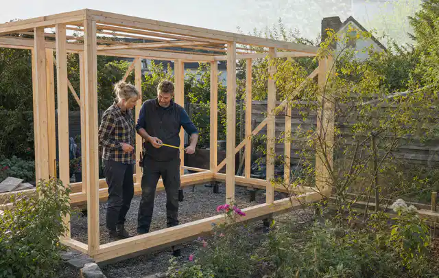 Person plant den Bau eines Gartenhauses auf einer vorbereiteten Fläche; Thema Gartenhaus Fundament, Schwerpunkt Nachhaltigkeit; Kontrolle.