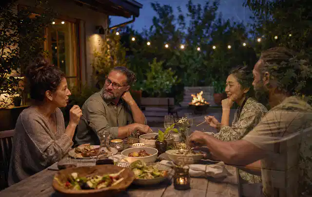 Menschen verbringen einen ruhigen Abend an einem Sitzplatz im Garten; Thema Gartenlounges, Schwerpunkt Anwendung; Umsetzung.