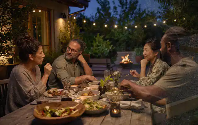 Menschen verbringen einen ruhigen Abend an einem Sitzplatz im Garten; Thema Gartenlounges, Schwerpunkt Bestenliste; Ergebnis.