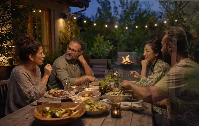 Menschen verbringen einen ruhigen Abend an einem Sitzplatz im Garten; Thema Gartenlounges, Schwerpunkt Dimensionierung; Ergebnis.