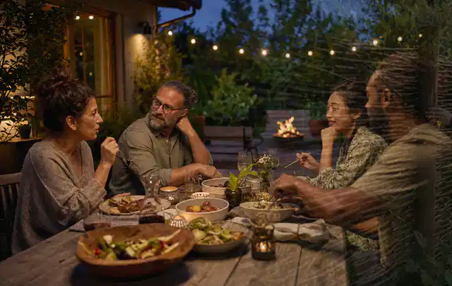 Menschen verbringen einen ruhigen Abend an einem Sitzplatz im Garten; Thema Gartenlounges, Schwerpunkt Sicherheit; Ergebnis.