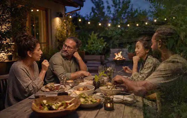 Menschen verbringen einen ruhigen Abend an einem Sitzplatz im Garten; Thema Gartenlounges, Schwerpunkt Systemvergleich; Ausgangslage.