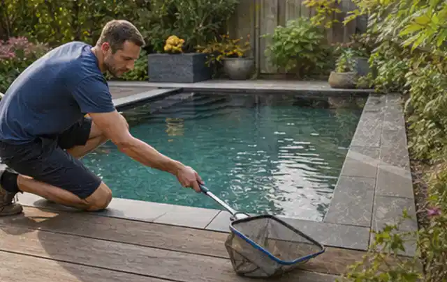 Person entfernt Blätter mit einem Kescher aus einem kleinen Gartenpool; Thema Gartenmöbel, Schwerpunkt Outdoor Freizeit; Ergebnis.