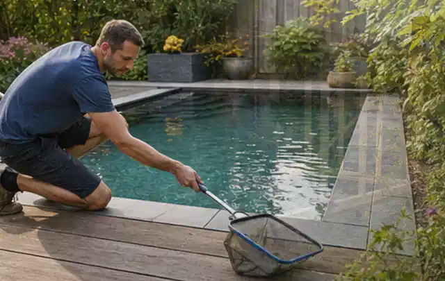 Person entfernt Blätter mit einem Kescher aus einem kleinen Gartenpool; Thema Gartenstühle, Schwerpunkt Ersatzteile; Kontrolle.