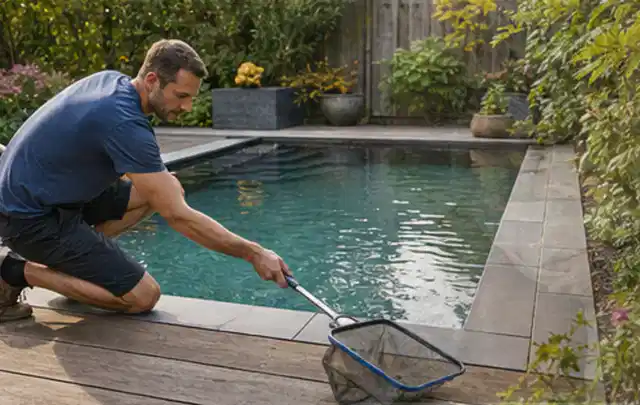 Person entfernt Blätter mit einem Kescher aus einem kleinen Gartenpool; Thema Gartentische, Schwerpunkt Fehlerhilfe; Kontrolle.