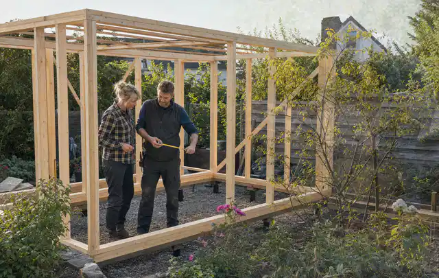 Person plant den Bau eines Gartenhauses auf einer vorbereiteten Fläche; Thema Gartenwerkstatt, Schwerpunkt Baurecht; Praxisalltag.
