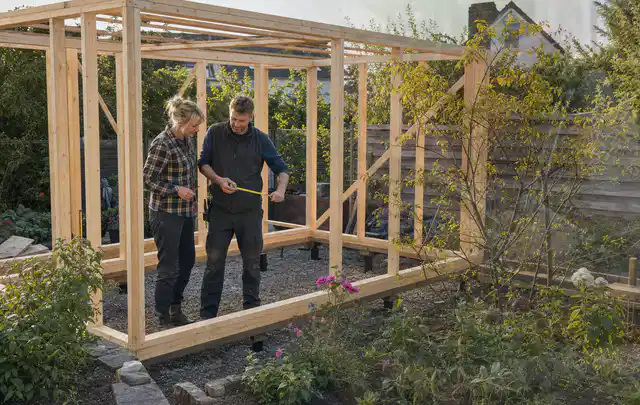 Person plant den Bau eines Gartenhauses auf einer vorbereiteten Fläche; Thema Gartenwerkstatt, Schwerpunkt Fehlerhilfe; Kontrolle.