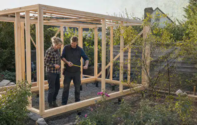 Person plant den Bau eines Gartenhauses auf einer vorbereiteten Fläche; Thema Gartenwerkstatt, Schwerpunkt Fundament; Ergebnis.