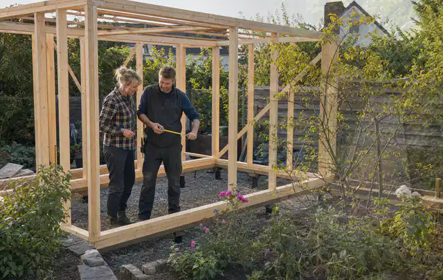 Person plant den Bau eines Gartenhauses auf einer vorbereiteten Fläche; Thema Gartenwerkstatt, Schwerpunkt Materialwahl; Praxisalltag.