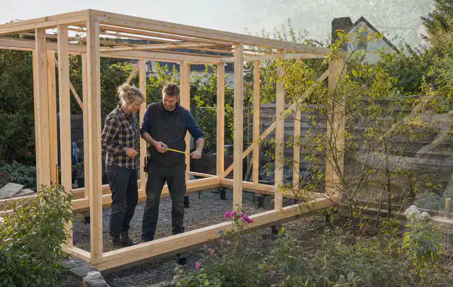 Person plant den Bau eines Gartenhauses auf einer vorbereiteten Fläche; Thema Gartenwerkstatt, Schwerpunkt Planung; Ergebnis.