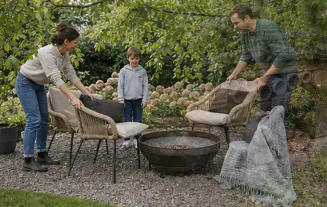 Familie stellt wetterfeste Sessel an einem geschützten Sitzplatz im Garten auf; Thema Gasgrills, Schwerpunkt Bestenliste; Ergebnis.