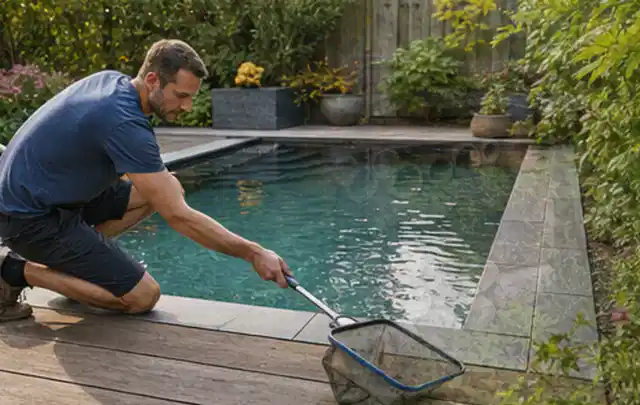Person entfernt Blätter mit einem Kescher aus einem kleinen Gartenpool; Thema Gasgrills, Schwerpunkt Checkliste; Umsetzung.