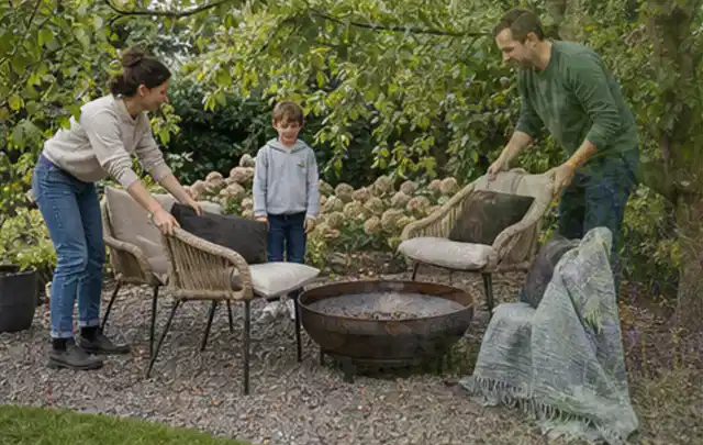 Familie stellt wetterfeste Sessel an einem geschützten Sitzplatz im Garten auf; Thema Gasgrills, Schwerpunkt Outdoor Freizeit; Ausgangslage.