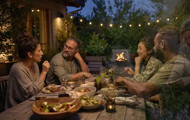 Menschen verbringen einen ruhigen Abend an einem Sitzplatz im Garten; Thema Gasgrills, Schwerpunkt Systemvergleich; Umsetzung.