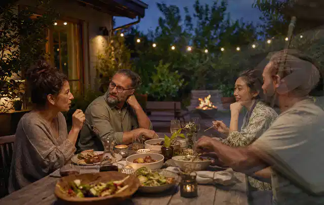 Menschen verbringen einen ruhigen Abend an einem Sitzplatz im Garten; Thema Gasgrills, Schwerpunkt Testkriterien; Ergebnis.