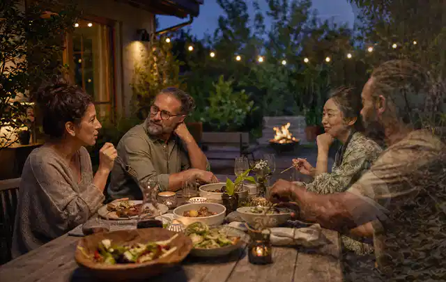 Menschen verbringen einen ruhigen Abend an einem Sitzplatz im Garten; Thema Gasgrills, Schwerpunkt Vergleich; Ergebnis.