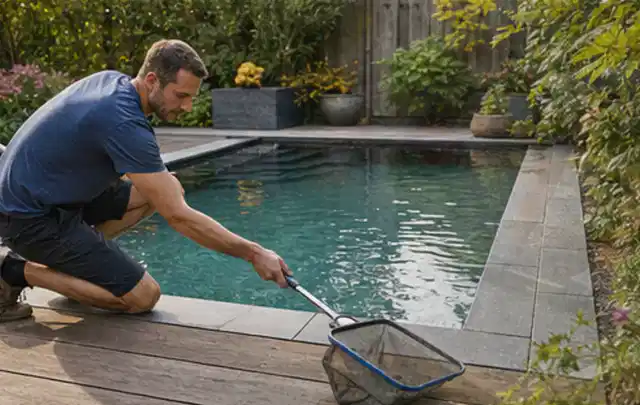 Person entfernt Blätter mit einem Kescher aus einem kleinen Gartenpool; Thema Gasgrills, Schwerpunkt Winterlager; Ausgangslage.