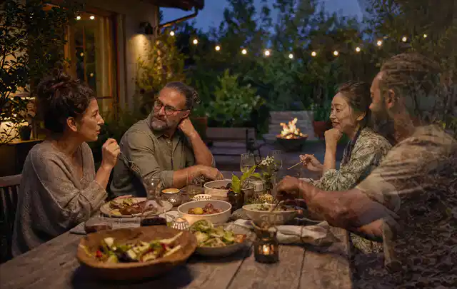 Menschen verbringen einen ruhigen Abend an einem Sitzplatz im Garten; Thema Gasgrills, Schwerpunkt Winterlager; Kontrolle.