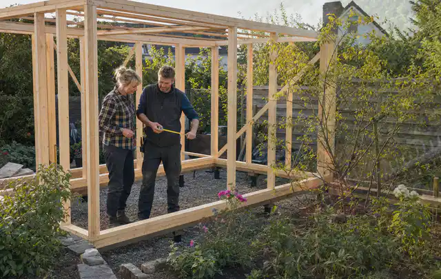 Person plant den Bau eines Gartenhauses auf einer vorbereiteten Fläche; Thema Geräteschuppen, Schwerpunkt Gärten mit kleiner Fläche; Kontrolle.