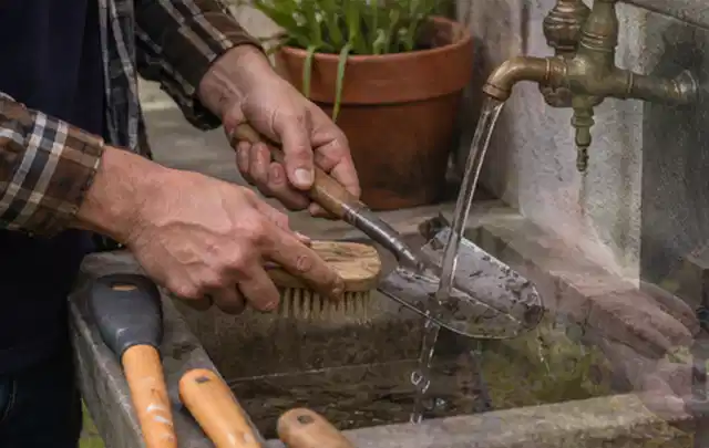 Hände reinigen gebrauchte Gartengeräte mit Bürste und Wasser am Außenbecken; Thema Heckenscheren, Schwerpunkt Dimensionierung; Ergebnis.