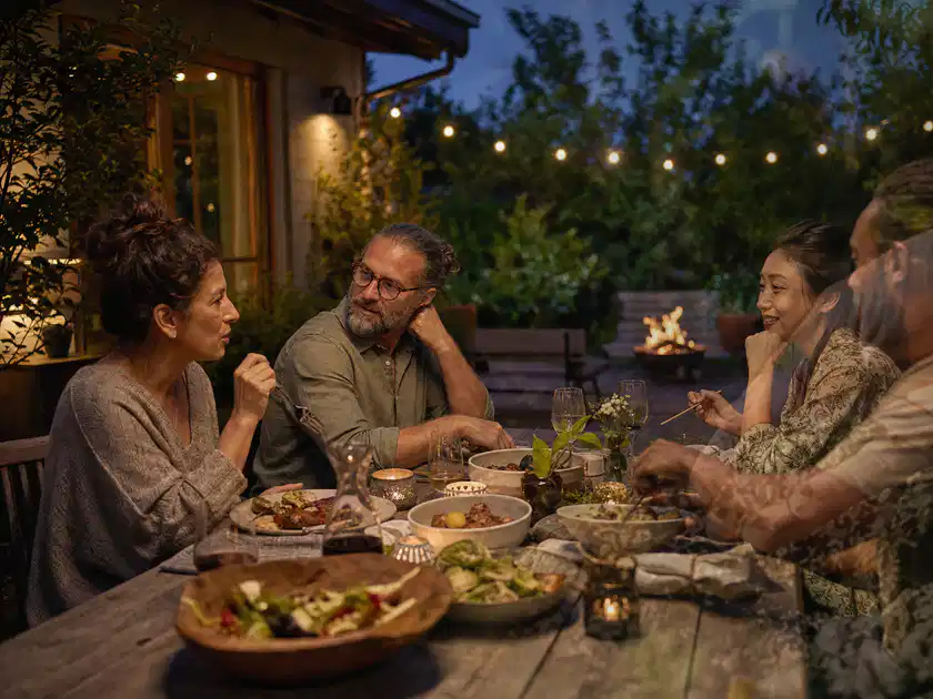 Menschen verbringen einen ruhigen Abend an einem Sitzplatz im Garten; Thema Hollywoodschaukeln, Schwerpunkt Fehlerhilfe; Titelbild.