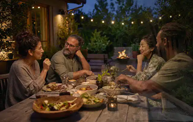 Menschen verbringen einen ruhigen Abend an einem Sitzplatz im Garten; Thema Hollywoodschaukeln, Schwerpunkt Sicherheit; Praxisalltag.
