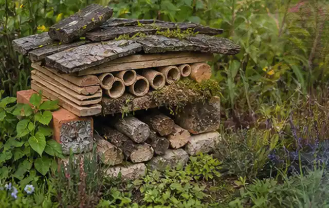 Naturnaher Unterschlupf aus Holz Rinde und Pflanzenstängeln im Garten; Thema Holzzäune, Schwerpunkt Dimensionierung; Praxisalltag.