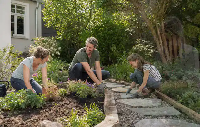 Familie geht auf einem Weg durch einen abwechslungsreich gestalteten Garten; Thema Holzzäune, Schwerpunkt Fehlerhilfe; Ausgangslage.