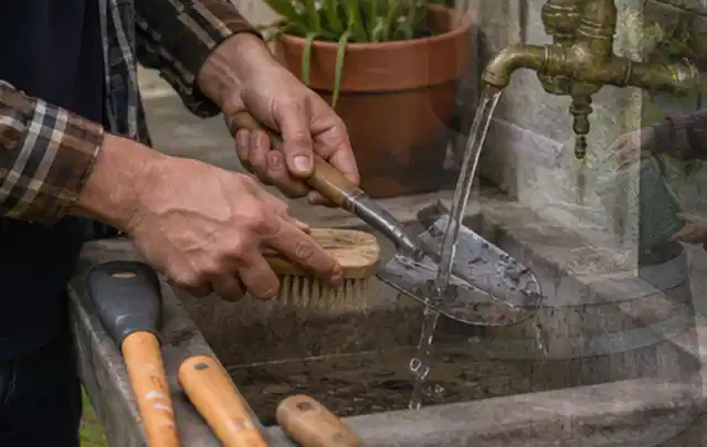 Hände reinigen gebrauchte Gartengeräte mit Bürste und Wasser am Außenbecken; Thema Husqvarna Automower, Schwerpunkt Kosten; Praxisalltag.
