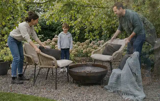 Familie stellt wetterfeste Sessel an einem geschützten Sitzplatz im Garten auf; Thema Insektenfreundlicher Garten, Schwerpunkt Bepflanzung; Ergebnis.