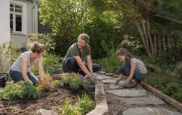 Familie geht auf einem Weg durch einen abwechslungsreich gestalteten Garten; Thema Insektenfreundlicher Garten, Schwerpunkt Fehlerhilfe; Praxisalltag.