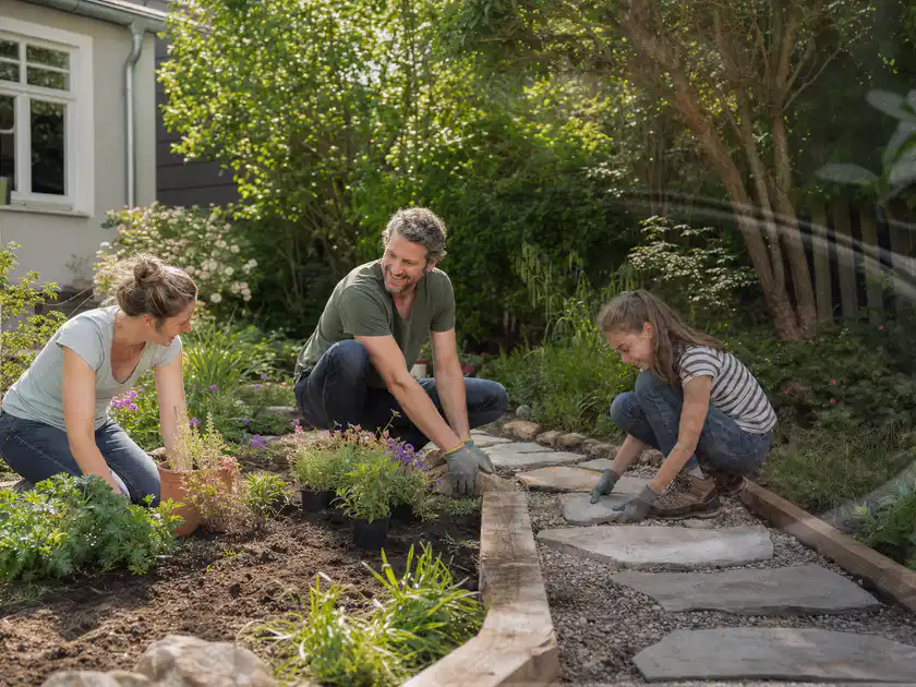 Familie geht auf einem Weg durch einen abwechslungsreich gestalteten Garten; Thema Insektenfreundlicher Garten, Schwerpunkt mit kleiner Fläche; Titelbild.