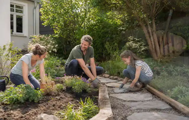 Familie geht auf einem Weg durch einen abwechslungsreich gestalteten Garten; Thema Insektenfreundlicher Garten, Schwerpunkt gestalten; Umsetzung.