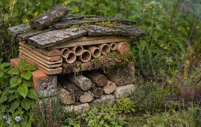 Naturnaher Unterschlupf aus Holz Rinde und Pflanzenstängeln im Garten; Thema Insektenfreundlicher Garten, Schwerpunkt Hanglage; Ergebnis.